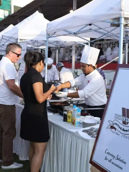 Service with a smile is our guarantee. Here is one of our professional chefs serving a freshly prepared pasta dish at a VIP lounge event at the Mahalaxmi Racecourse. We ensure your guests feel welcomed and well-cared for.