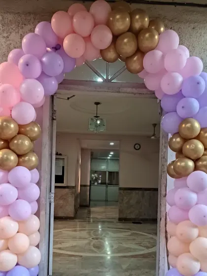 This balloon arch in pastel pink, purple, and gold creates a beautiful entryway for a baby shower celebration. It's a great way to welcome your guests.