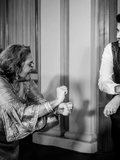 A fun dance moment between a young man and an older woman, showing the joy that brings all family members together on the dance floor.