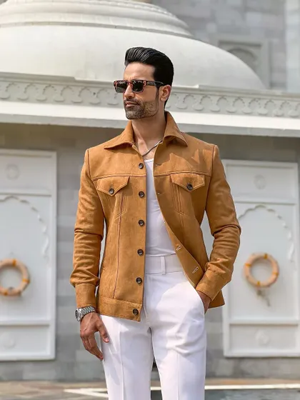The Sand Rambler jacket styled in front of classic architecture, highlighting its timeless appeal and sophisticated design.
