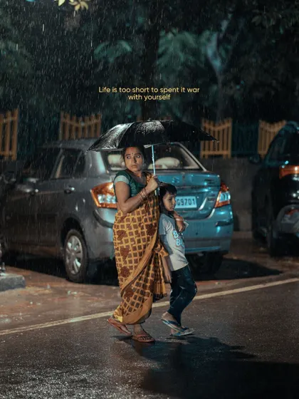 A mother and child walking in the rain. This simple, relatable moment is filled with a sense of care and protection, a quiet story unfolding on a wet city street.