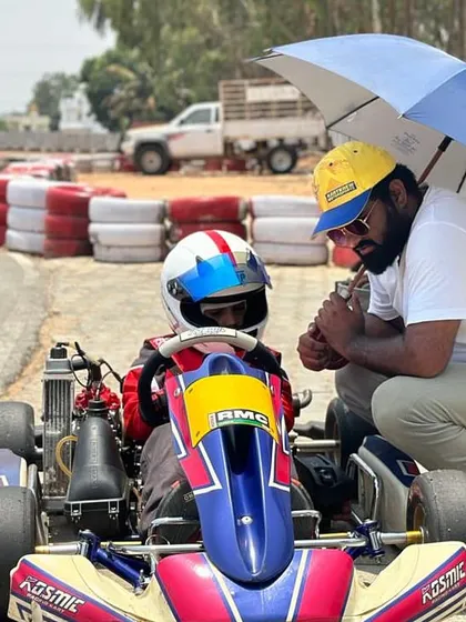 A coach giving advice to a young driver under an umbrella.