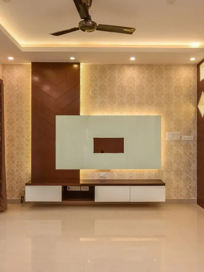 This image shows the complete TV wall with its chevron-patterned wood panel, floating console, and decorative partition. The combination of different materials and lighting creates a dynamic and stylish focal point.