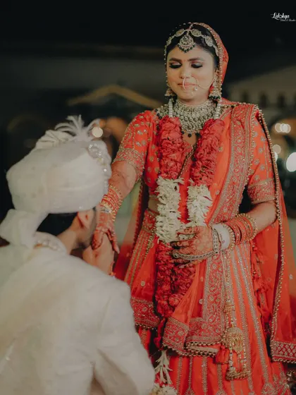 A gesture of chivalry and love. The groom gently kisses the bride's hand, a timelessly romantic moment captured during their wedding ceremony.