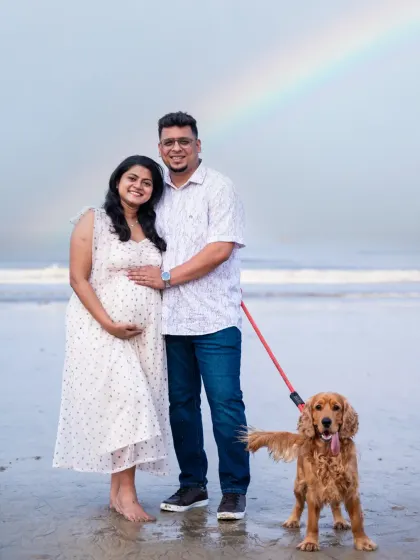 Sometimes, nature gives us a special gift. This beautiful family portrait, complete with their beloved dog and a surprise rainbow, makes for an unforgettable memory from their beach maternity photoshoot.