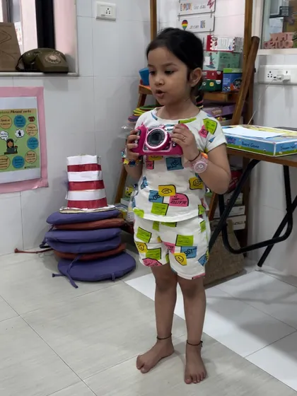 This young student chose her toy camera for "Share and Shine." It's a wonderful opportunity for her to practice speaking in front of her peers about an object that is important to her.