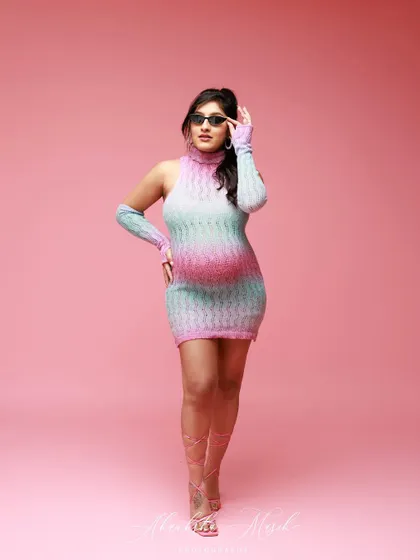 Strutting with style, this mom-to-be rocks a colorful knit dress and sunglasses for a fun, high-fashion Barbie-themed shot.