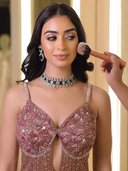A behind-the-scenes shot of the final powder touch-up. This ensures the makeup is perfectly set and remains flawless throughout the event.