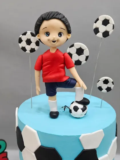 The top figurine of the football anti-gravity cake, surrounded by floating soccer balls. Each element is carefully placed to create a sense of action.