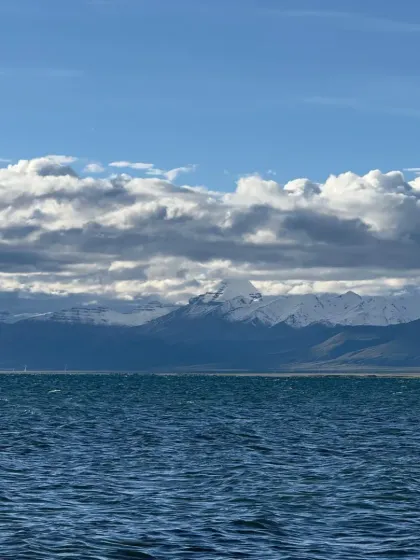 The deep blue expanse of Lake Mansarovar under a sky full of clouds, with the Himalayan range in the distance. This is a landscape that silences the mind.