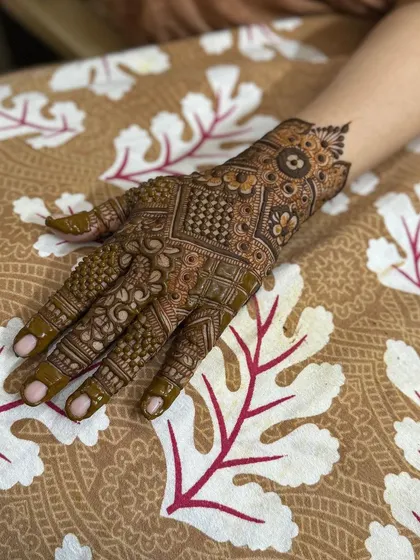 A complete view of the intricate back-hand henna design.