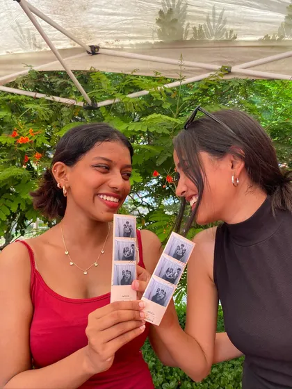 Two friends sharing a laugh and their matching photo strips.