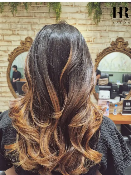 A warm, coppery balayage that adds incredible richness and shine, styled into glamorous waves.