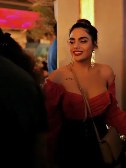 A guest looking radiant in red, enjoying the action-packed night on the beautiful new rooftop.