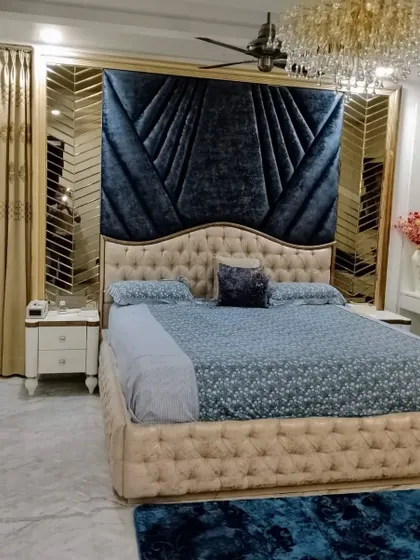 For clients who dream of opulence, we create bedrooms that are pure luxury. This design features a custom velvet headboard, intricate mirror paneling, and a statement chandelier to create a space that feels both grand and deeply comfortable.