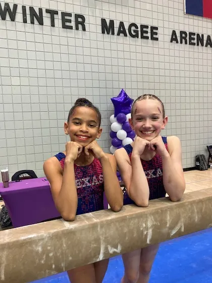 Two of our Development Program Level 6 gymnasts taking a break on the beam during their state meet.