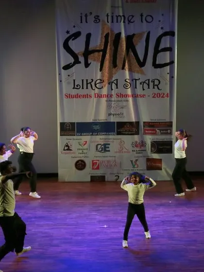 A wide shot of the group in action, filling the stage with energy and movement.