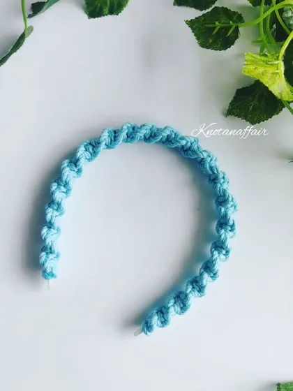 A close-up of the light blue macrame spiral knot hairband. The simple yet elegant design is perfect for any occasion.