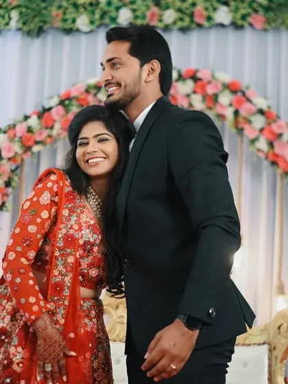 A warm, happy hug after the proposal. This photo radiates the comfort and joy the couple feels, captured against the beautiful floral decor of their engagement stage.