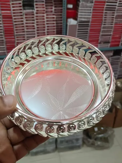 A hand-held view of the round German silver tray, showing its intricate swirled rim. I have these available in multiple sizes.