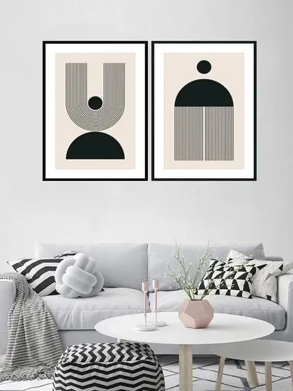 A set of two framed prints featuring austere geometric shapes in black and white. This minimalist artwork is perfect for a modern living room, adding a touch of graphic sophistication. Frame color and size are customizable.