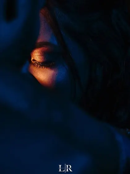 An artistic close-up shot focusing on the bride's eye, with dramatic blue and orange lighting. This is an example of our fearless approach to creating unique and captivating images.