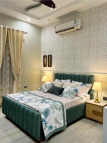 This bedroom uses a refreshing green color palette with floral-patterned bedding and a simple, elegant headboard. The design brings a touch of nature indoors, creating a fresh and restful space.