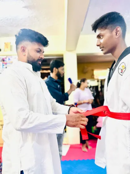 A senior student receives his red belt, showing he is approaching the level of black belt.