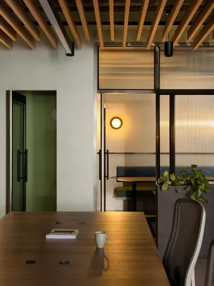 Transparency was a key theme for this finance company. This view from the main work area looks through fluted glass partitions into a breakout space, illustrating how we create visual connection between different areas while still providing a degree of privacy.
