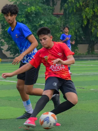 A player in our red kit on the attack, looking to take on a defender.