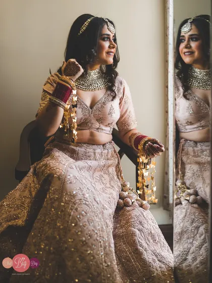 The bride, Simrita, admires her reflection, a happy and confident moment before the ceremony begins.