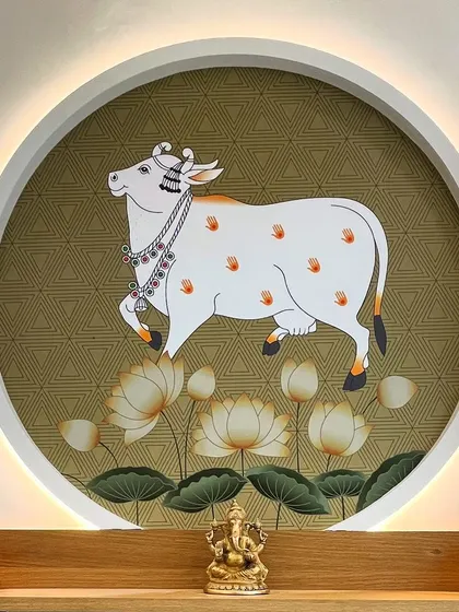 A beautiful detail of a Pichwai wallpaper artwork featuring a sacred cow, framed within a circular niche with backlighting. This creates a divine and artistic focal point in the living room.