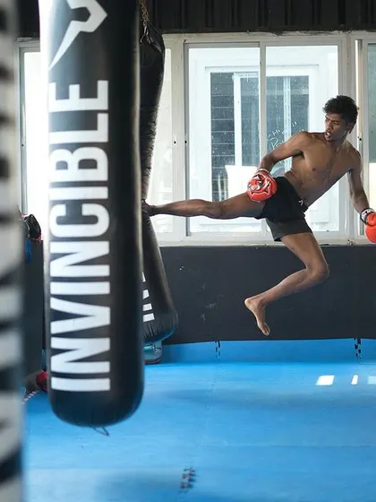 A snapshot of a dynamic flying kick connecting with the heavy bag. This kind of plyometric drill builds explosive power in your legs, essential for effective kickboxing and Muay Thai.