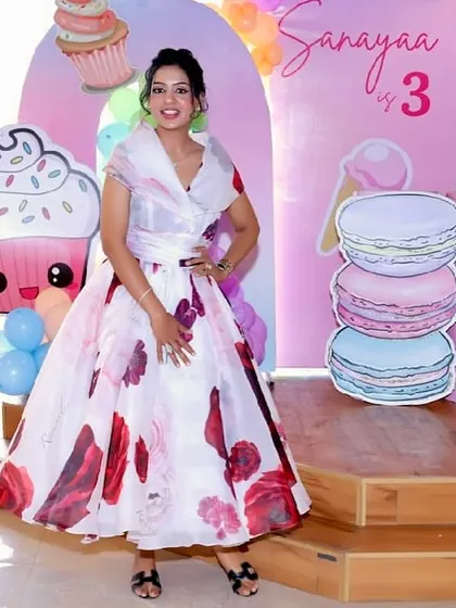 A guest poses in a beautiful floral dress at a Candyland-themed party.