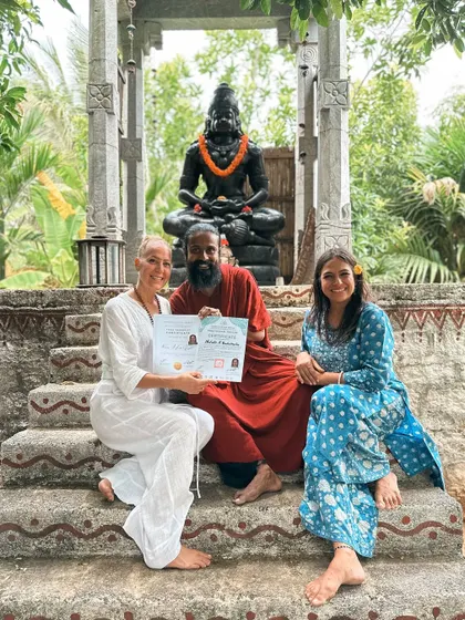 A graduate receives her certificate, her face beaming with joy. This moment marks not an end, but the beginning of a new chapter as a confident and knowledgeable yoga teacher.