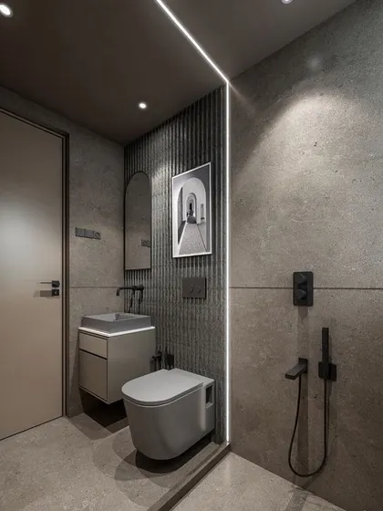 For a bold, masculine look, I used large-format grey concrete-finish tiles throughout this bathroom. The vertical LED strip light dramatically separates the wet and dry areas while adding a futuristic touch. All fixtures are in a modern matte black finish.