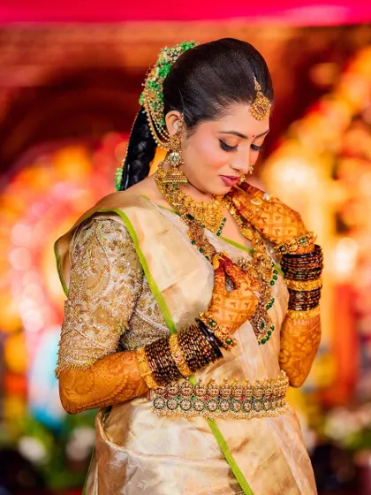 A close-up of the bride's beautiful smile and her intricate gold jewelry. The details of her custom blouse are simply breathtaking.