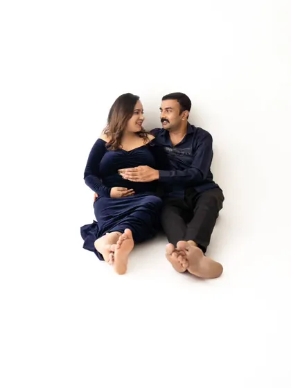 A fun and relaxed pose with the couple sitting on the floor together, sharing a happy and intimate moment.