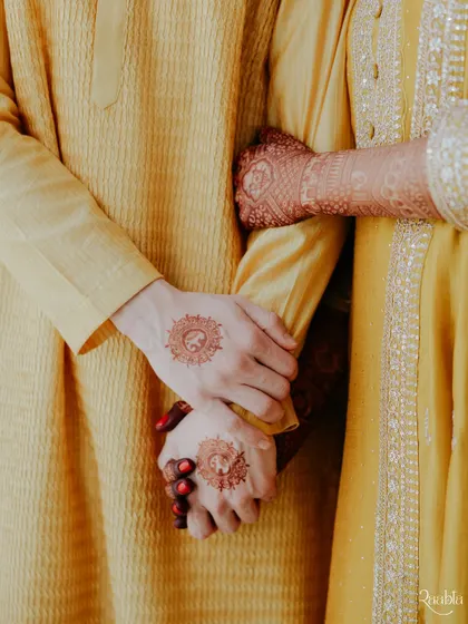 A close-up of the couple's hands, showing the intricate henna designs and the simple act of holding on, from a soulful Mumbai wedding.