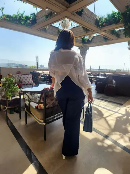 The back view of the asymmetrical white shirt, showing how unconventional cuts can elevate a simple outfit.