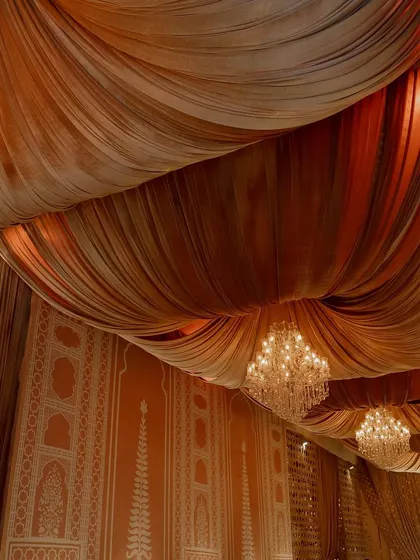 The ceiling of the dining hall was draped in luxurious fabric, with crystal chandeliers providing a soft, ambient light. This creates a sense of intimacy and grandeur.
