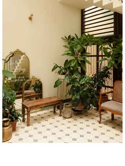 This corner of the courtyard at Casa 503 is filled with lush plants and vintage-inspired furniture. The patterned floor tiles and natural light make it a perfect spot to unwind.
