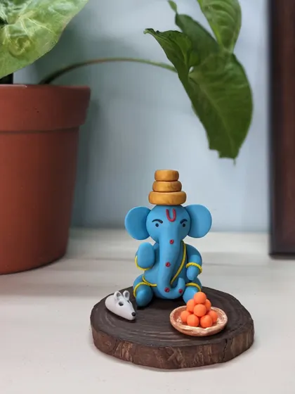 A small idol with a big presence. This blue Ganesha, complete with his mushak and laddoos, brings the entire feeling of a puja corner to your desk or shelf.