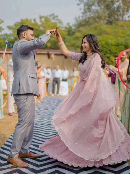 The couple shares their first dance as an engaged couple. The bride's twirling lehenga and their happy faces capture the joy of the celebration.