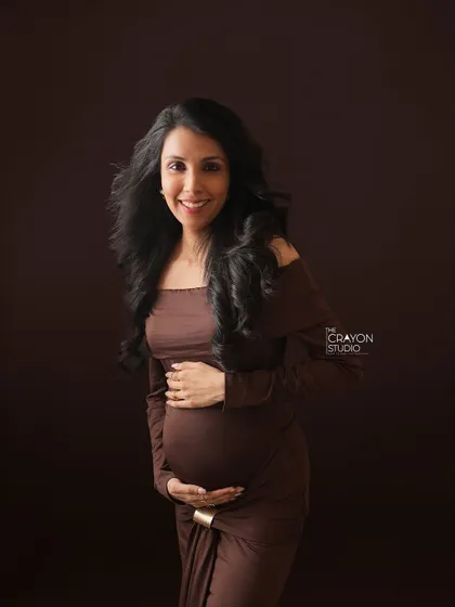 A bright, happy smile contrasts beautifully with the moody, dark background. This portrait shows that fine art photography can be both elegant and full of joy.