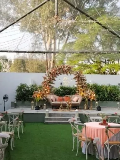 We designed this stunning outdoor engagement party within a clear-span tent, allowing for an open, airy feel. The setup includes a beautiful floral arch stage, elegant table settings, and romantic lighting.