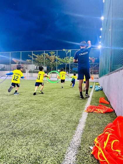 A coach leads a fun running drill with hoops. We mix up our training with creative exercises to keep the kids engaged and motivated.