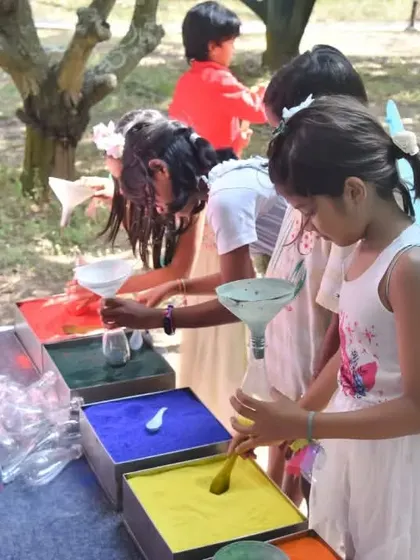 We organize engaging activities to keep children entertained. Here, young guests are having fun at a sand art station, creating their own colorful party favors.