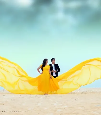 This yellow flying gown paired with a black suit is a classic combination for a dramatic and beautiful pre-wedding photoshoot on the sand.