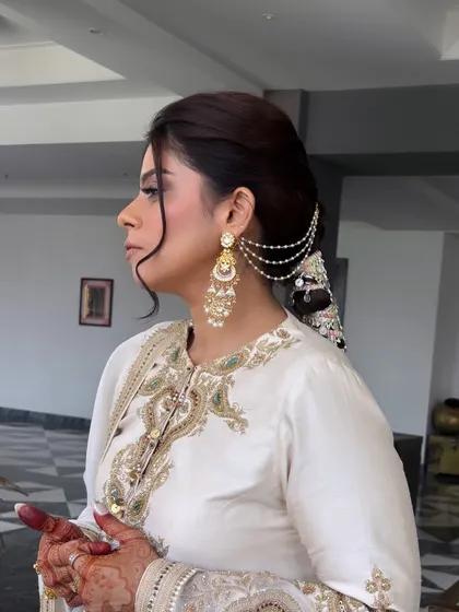 A side profile of the client wearing the embellished braid. The front is styled with a soft, face-framing wave, balancing the drama of the braid. This demonstrates how to create a complete, balanced look.
